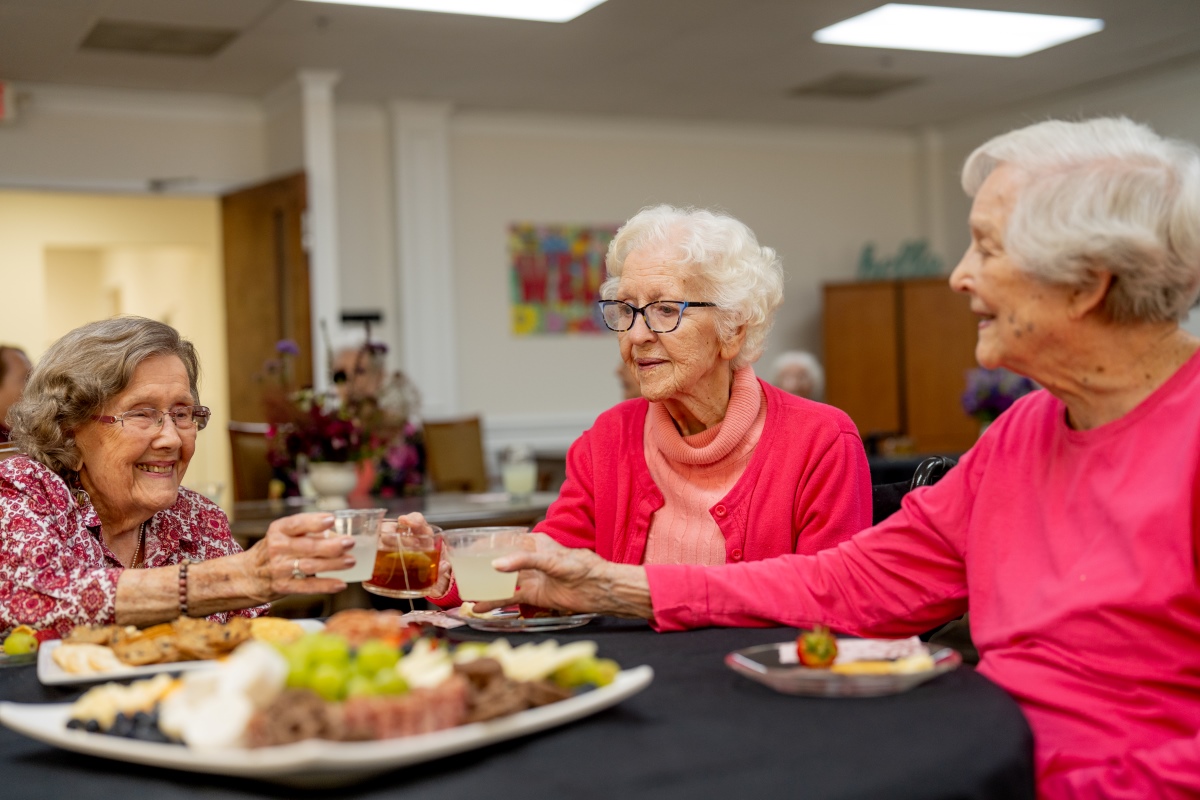 ladies holding glasses and enjoying social hour with light snacks and beverages