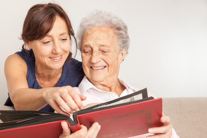 woman looking through book with older female