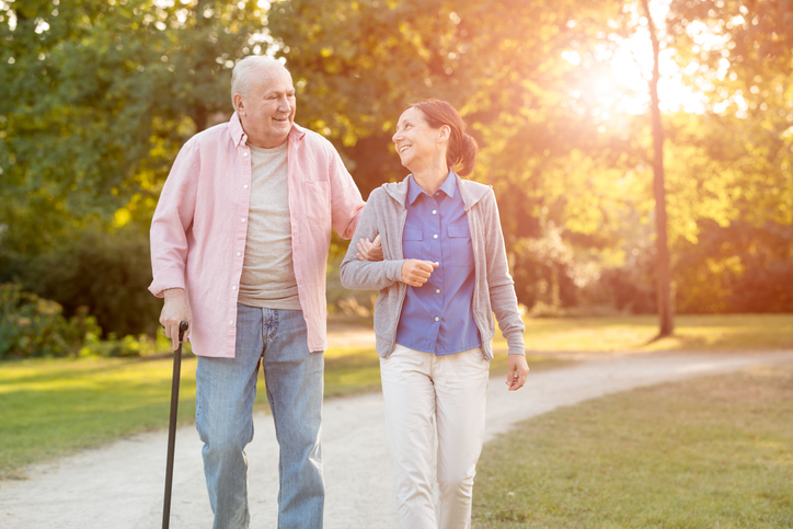 caregiver assisting older male on a walk