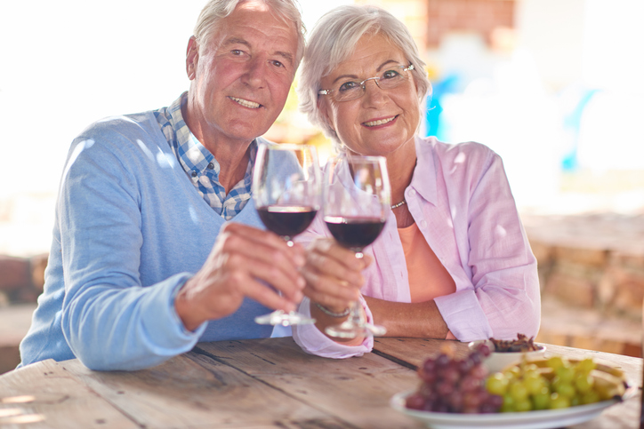 older couple holding wine glasses